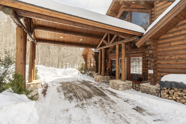 interior space featuring vaulted ceiling with beams, log walls, and wooden ceiling