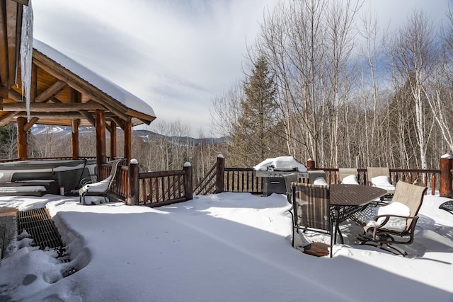 snow covered deck with a hot tub