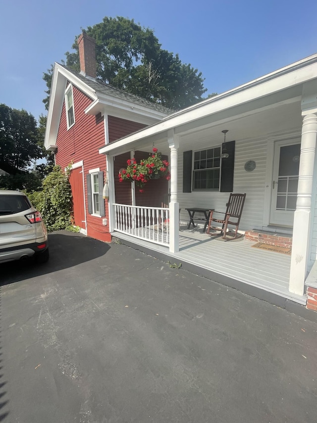 view of front of house with covered porch and a chimney