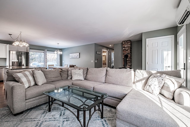 living room featuring an inviting chandelier, wood-type flooring, and a wall unit AC