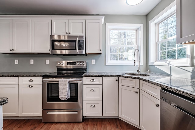 kitchen with stainless steel appliances, stone countertops, sink, and white cabinets