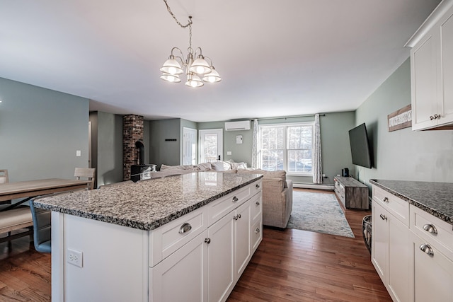 kitchen featuring a kitchen island, pendant lighting, white cabinets, a baseboard heating unit, and dark wood-type flooring