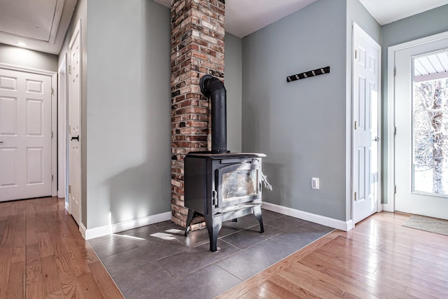 foyer entrance with a wood stove and dark wood-type flooring