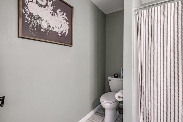 bathroom featuring curtained shower and toilet