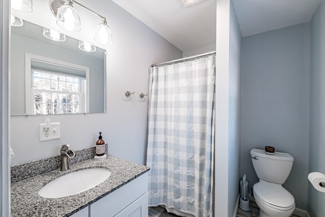 bathroom featuring vanity, toilet, and walk in shower