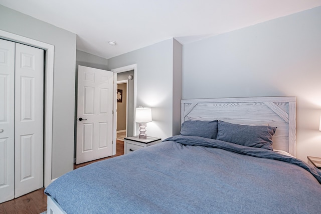 bedroom with dark hardwood / wood-style floors and a closet