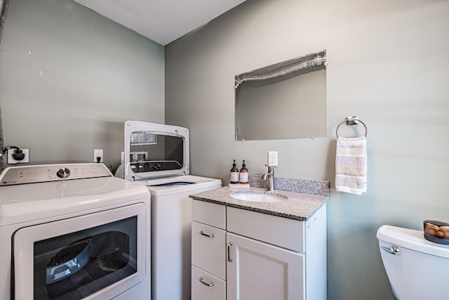 clothes washing area featuring sink and washer and dryer