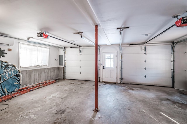 garage featuring a wall mounted air conditioner, a garage door opener, and electric panel