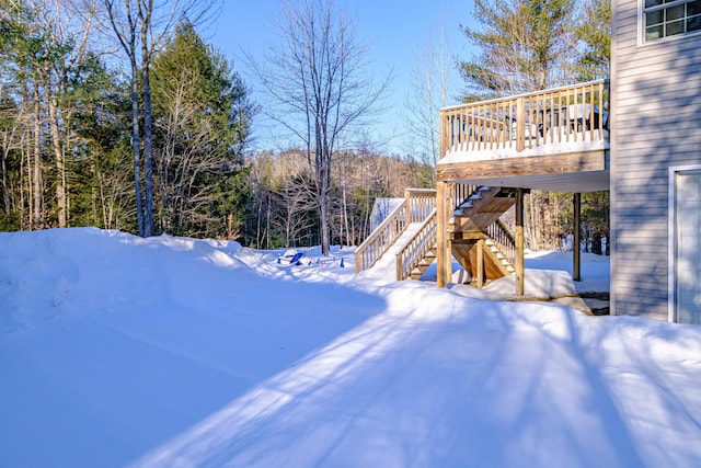 yard layered in snow with a deck