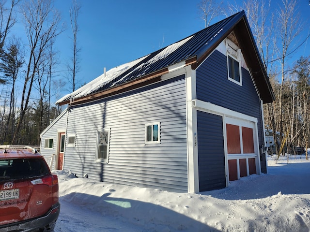 view of snowy exterior featuring a garage