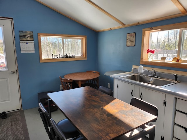 kitchen featuring lofted ceiling, sink, and white cabinets