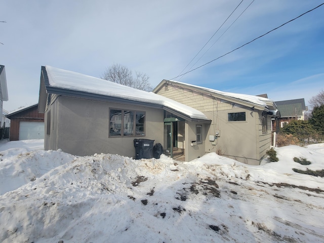 exterior space with an outbuilding, a detached garage, and stucco siding