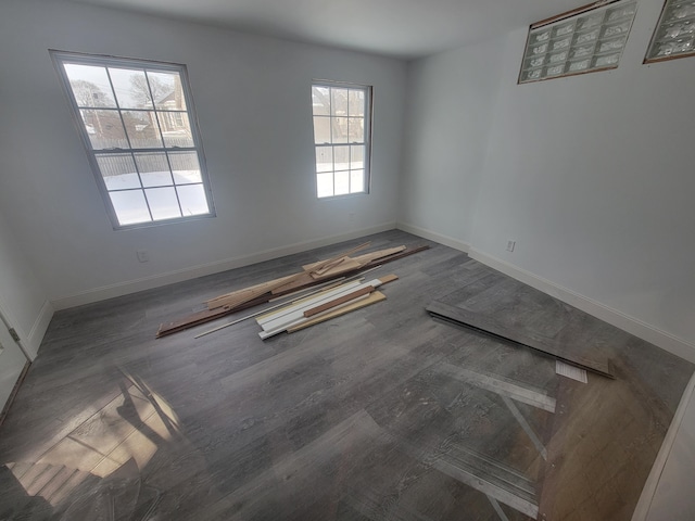 unfurnished room with dark wood-style flooring and baseboards