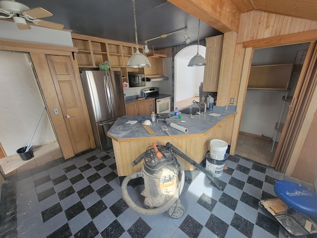 kitchen featuring arched walkways, dark floors, hanging light fixtures, a peninsula, and stainless steel appliances