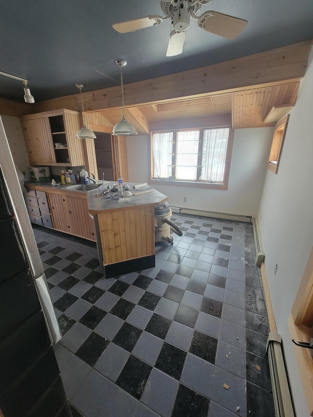 kitchen with open shelves, light countertops, light brown cabinetry, pendant lighting, and a sink