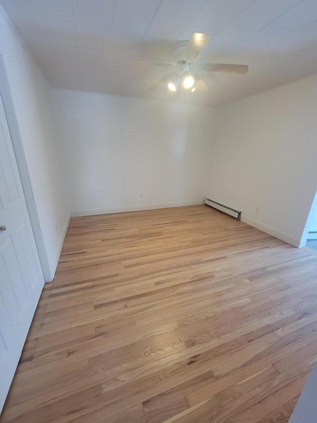 unfurnished room with baseboards, baseboard heating, light wood-style flooring, and a ceiling fan