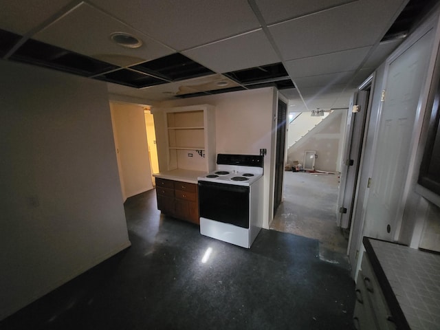 kitchen featuring a drop ceiling, electric range, concrete floors, light countertops, and brown cabinetry