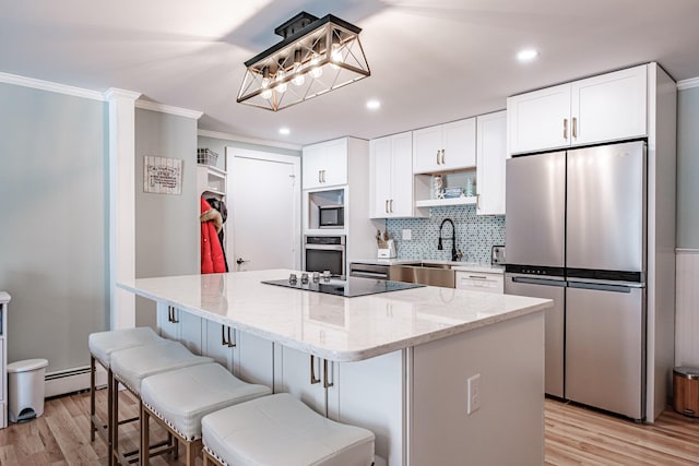 kitchen with white cabinets, a center island, stainless steel appliances, and sink