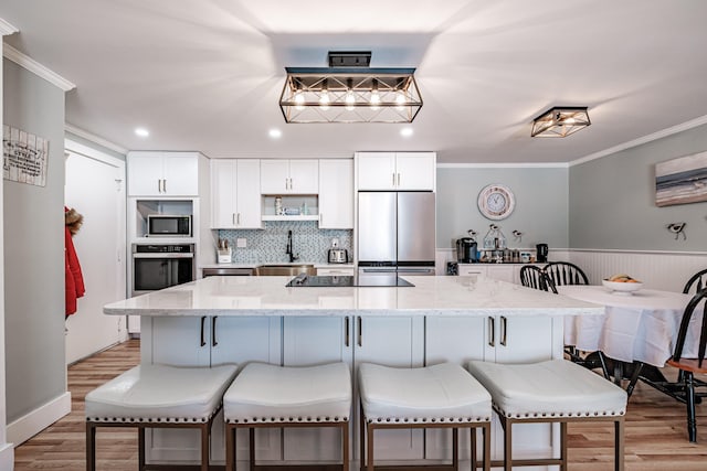 kitchen featuring sink, appliances with stainless steel finishes, white cabinetry, and light stone countertops