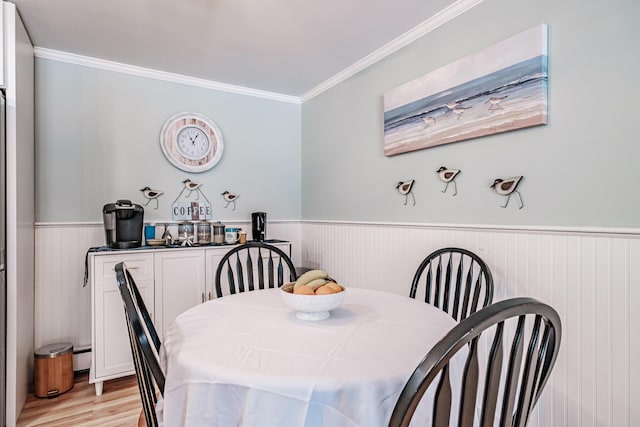 dining space featuring light hardwood / wood-style floors and ornamental molding