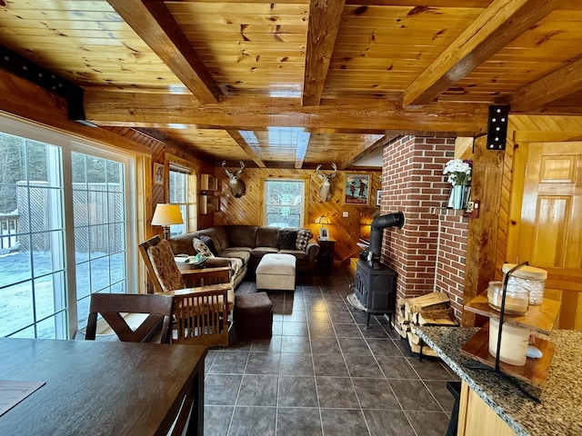 tiled living room featuring wood ceiling, wooden walls, beamed ceiling, and a wood stove