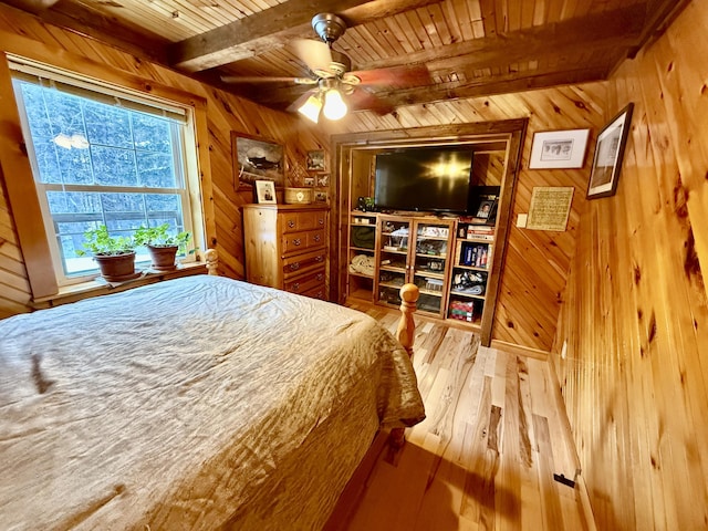 bedroom featuring wooden walls, light hardwood / wood-style floors, beam ceiling, and wooden ceiling