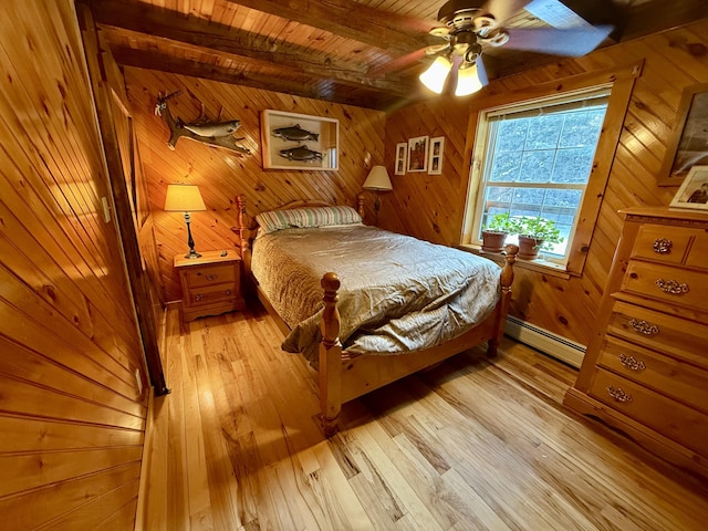 bedroom featuring wood ceiling, ceiling fan, a baseboard heating unit, light wood-type flooring, and wood walls