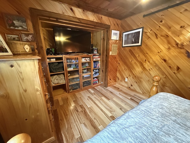 bedroom featuring hardwood / wood-style floors and wood walls