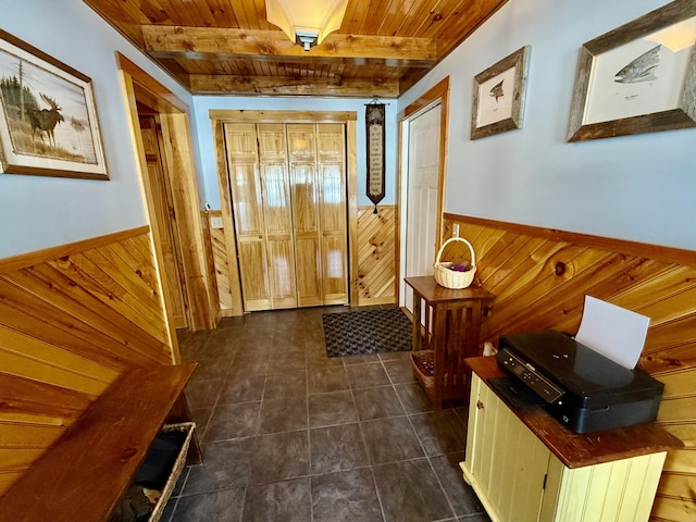 doorway to outside featuring beam ceiling, wooden ceiling, and wood walls