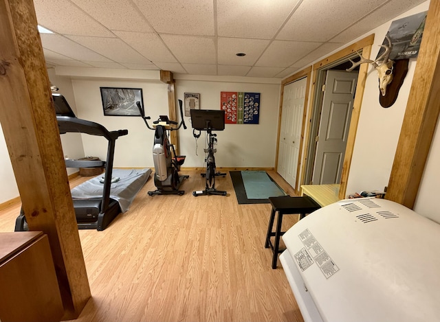 workout room featuring hardwood / wood-style flooring and a paneled ceiling