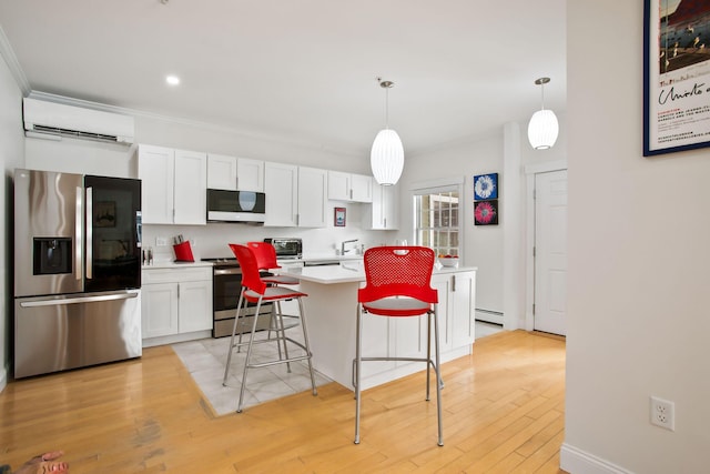 kitchen with a wall mounted AC, hanging light fixtures, white cabinetry, and stainless steel appliances