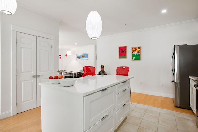 kitchen featuring a kitchen island, crown molding, stainless steel fridge, white cabinets, and hanging light fixtures