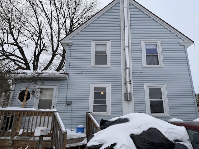 view of snow covered rear of property