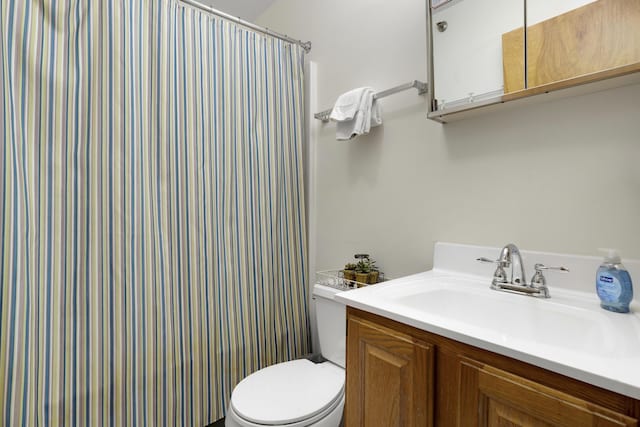 bathroom with vanity, curtained shower, and toilet