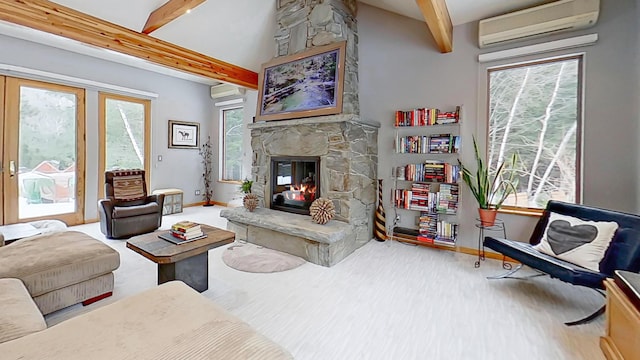 living area with a stone fireplace, a wall mounted AC, and plenty of natural light