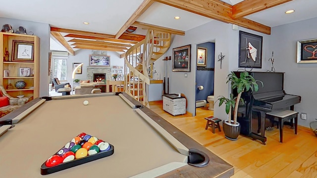 playroom with pool table, a lit fireplace, wood finished floors, and beamed ceiling