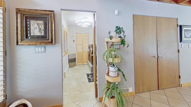 hallway featuring light tile patterned floors and baseboards