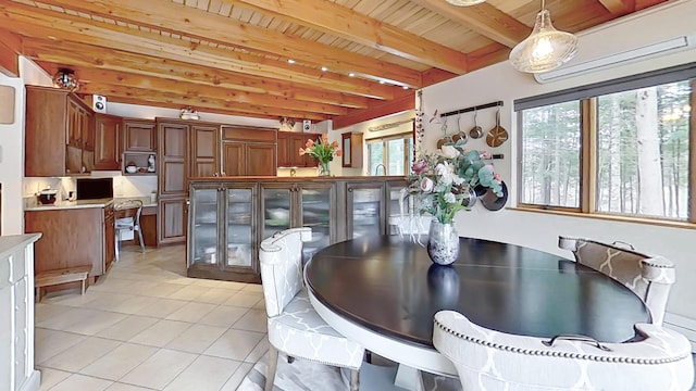 dining room with light tile patterned floors, wood ceiling, and beam ceiling