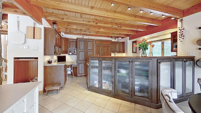 kitchen featuring wood ceiling, light countertops, beamed ceiling, and light tile patterned flooring