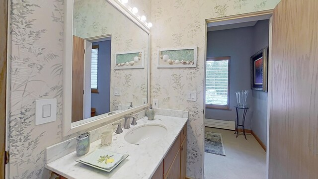 bathroom with vanity, baseboards, and wallpapered walls