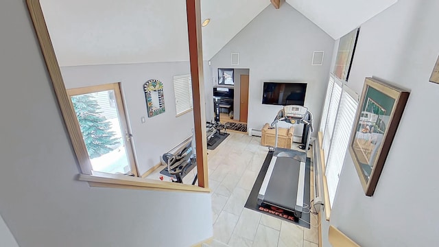 workout room with a baseboard heating unit, high vaulted ceiling, and wood finished floors