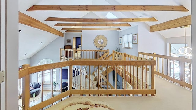 interior space featuring high vaulted ceiling, beam ceiling, and an upstairs landing