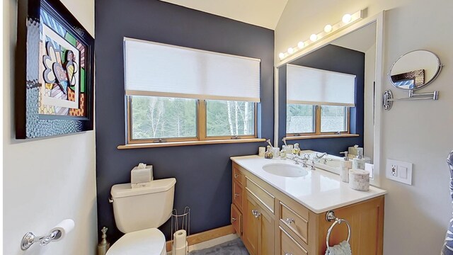 bathroom featuring baseboards, vanity, and toilet