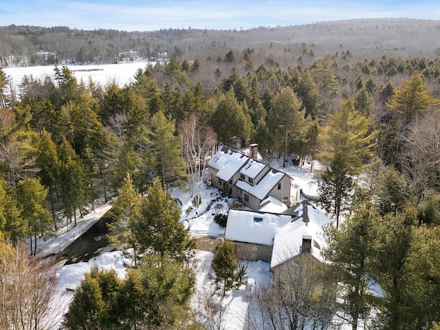 snowy aerial view featuring a forest view