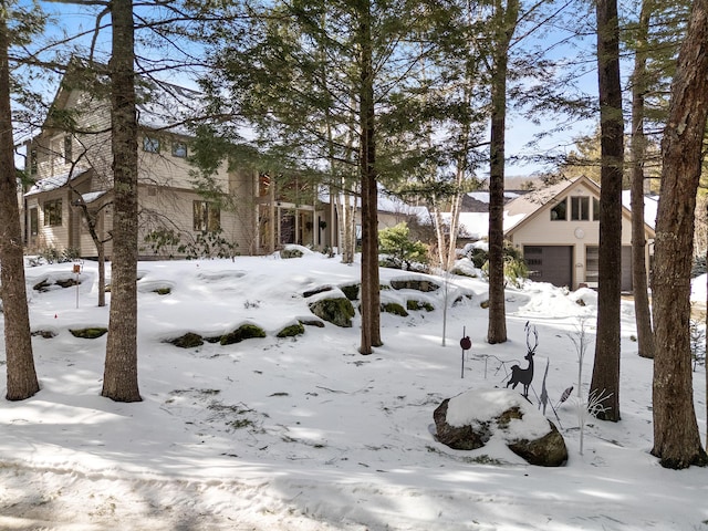 yard layered in snow featuring a garage