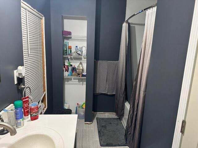 bathroom featuring shower / bathtub combination with curtain and sink