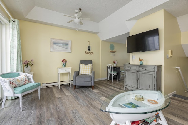 sitting room featuring ceiling fan, wood-type flooring, a textured ceiling, and a baseboard heating unit