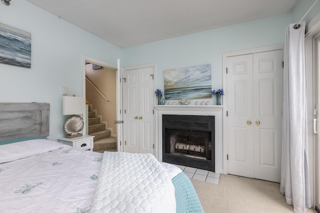 carpeted bedroom with multiple closets and a textured ceiling