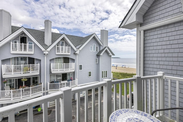 balcony featuring a water view and a view of the beach