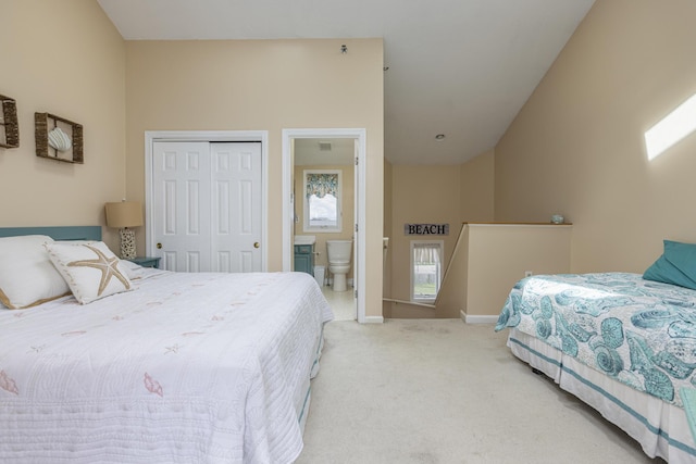 carpeted bedroom with ensuite bathroom and a closet